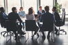 a group of people sitting in a meeting 